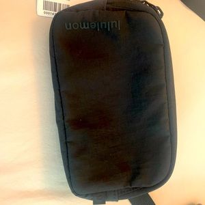 NWT New with tags Lululemon mini belt bag in black with adjustable strap.